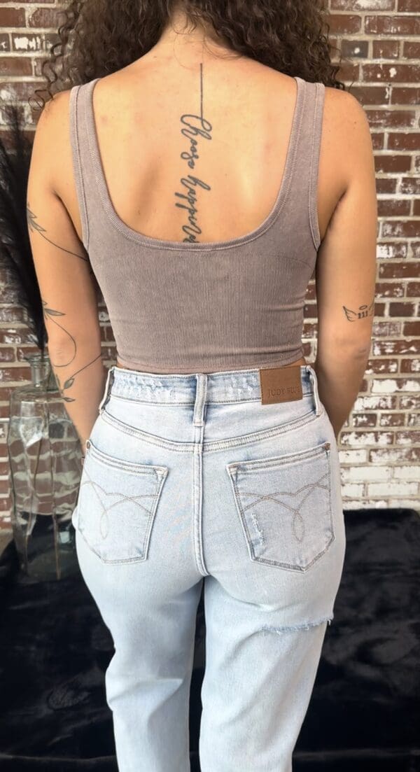 A woman with tattoos on her arms and back of her body.